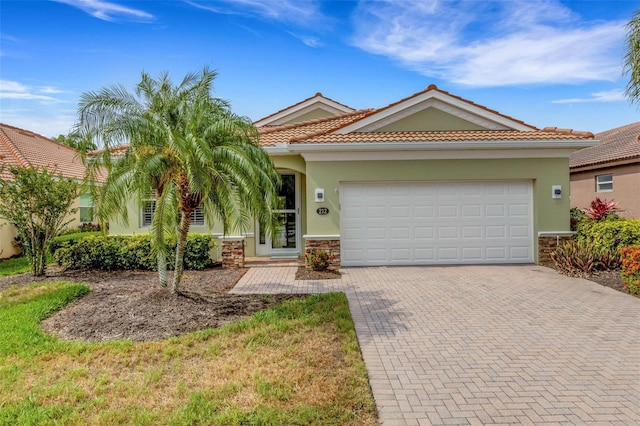 212 River Enclave Ct, Bradenton, FL 34212 - view of front facade with decorative driveway, stucco siding, a garage, stone siding, and a tile roof