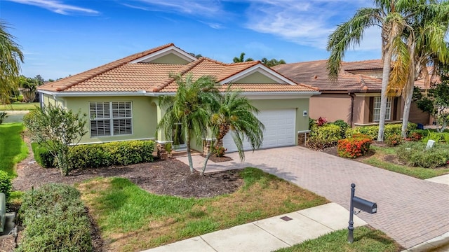 212 River Enclave Ct, Bradenton, FL 34212 - view of front facade featuring a garage, decorative driveway, stucco siding, and a tiled roof