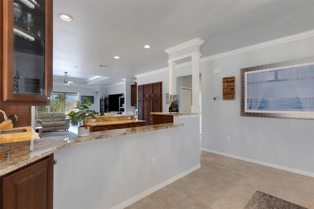 212 River Enclave Ct, Bradenton, FL 34212 - kitchen featuring ornamental molding, a sink, light stone counters, a peninsula, and glass insert cabinets