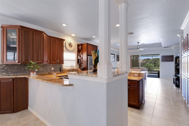 212 River Enclave Ct, Bradenton, FL 34212 - kitchen with ornate columns, crown molding, backsplash, light stone countertops, and light tile patterned floors