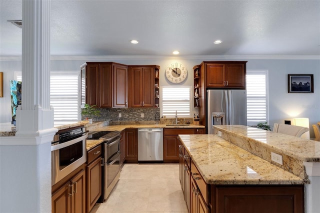 212 River Enclave Ct, Bradenton, FL 34212 - kitchen featuring appliances with stainless steel finishes, plenty of natural light, a center island, a sink, and crown molding