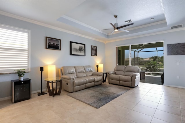 212 River Enclave Ct, Bradenton, FL 34212 - living area with ceiling fan, a raised ceiling, ornamental molding, light tile patterned flooring, and baseboards