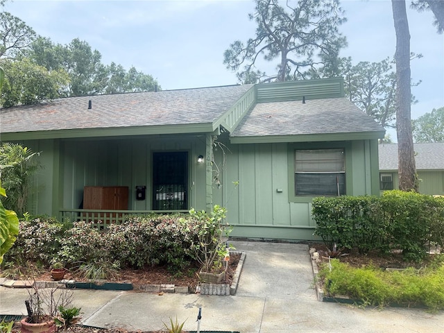 5014 Barrington Cir Unit 2102, Sarasota, FL 34234 - view of exterior entry featuring board and batten siding, a shingled roof, and a porch