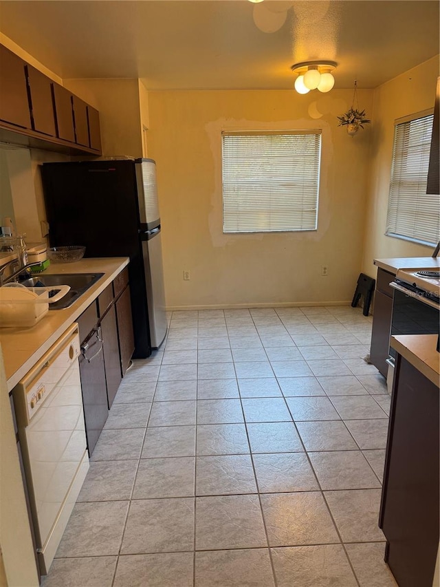 5014 Barrington Cir Unit 2102, Sarasota, FL 34234 - kitchen with white dishwasher, a sink, light tile patterned floors, freestanding refrigerator, and light countertops
