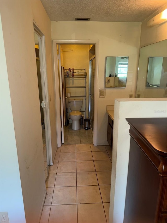 5014 Barrington Cir Unit 2102, Sarasota, FL 34234 - full bathroom featuring vanity, toilet, tile patterned flooring, a shower stall, and a textured ceiling