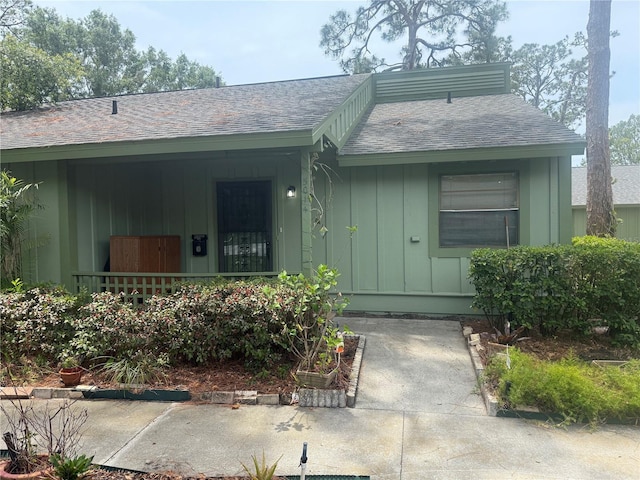 5014 Barrington Cir Unit 2102, Sarasota, FL 34234 - view of exterior entry featuring a shingled roof, a porch, and board and batten siding