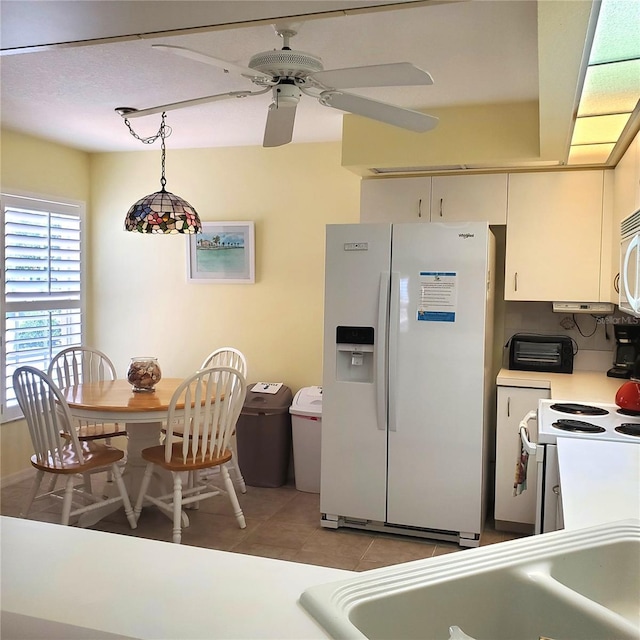 802 Montrose Dr Unit 204, Venice, FL 34293 - kitchen featuring white appliances, light countertops, light tile patterned flooring, a ceiling fan, and hanging light fixtures