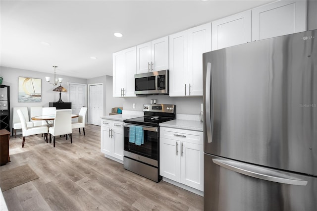 2726 Knoll St E, Palm Harbor, FL 34683 - kitchen featuring appliances with stainless steel finishes, light countertops, white cabinetry, recessed lighting, and light wood finished floors