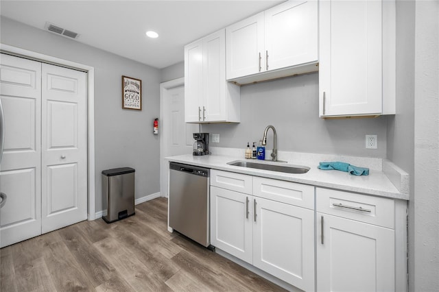 2726 Knoll St E, Palm Harbor, FL 34683 - kitchen with stainless steel dishwasher, white cabinetry, wood finished floors, and recessed lighting