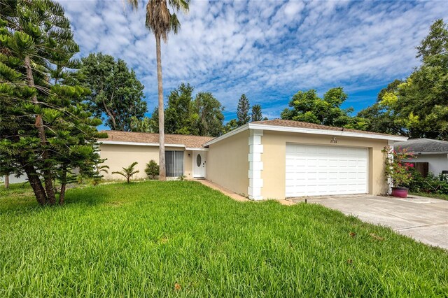 2726 Knoll St E, Palm Harbor, FL 34683 - ranch-style home with stucco siding, an attached garage, a front lawn, and concrete driveway