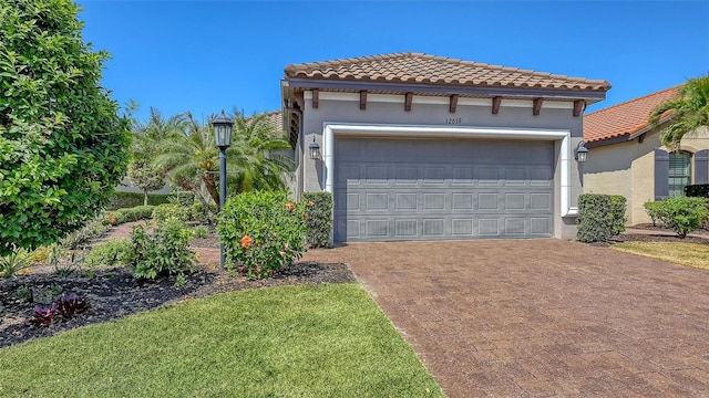 view of front facade featuring decorative driveway, a tiled roof, stucco siding, and a garage