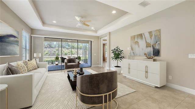 living area featuring ceiling fan, baseboards, recessed lighting, light tile patterned flooring, and a raised ceiling