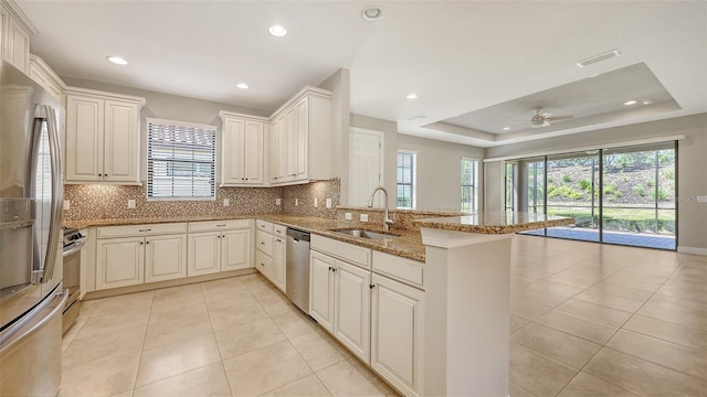kitchen featuring a sink, a peninsula, plenty of natural light, backsplash, and recessed lighting