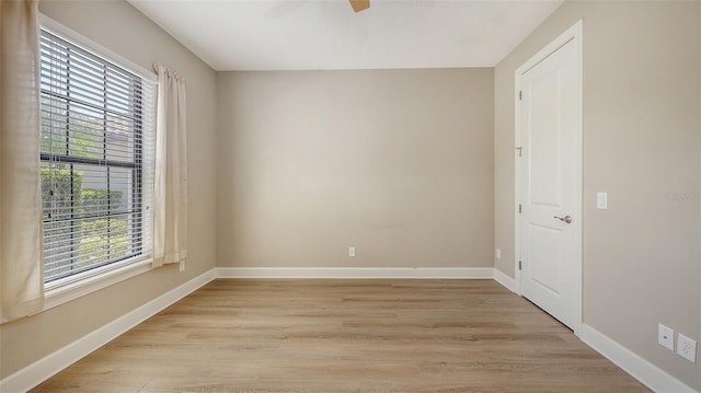 spare room with light wood-style flooring, baseboards, and a ceiling fan