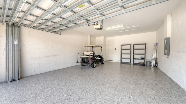 garage featuring electric panel, a garage door opener, and concrete block wall