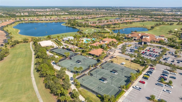 view of property location featuring a large body of water, a local golf course, and nearby suburban area
