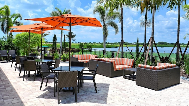 view of patio / terrace featuring an outdoor living space, fence, a water view, and outdoor dining area