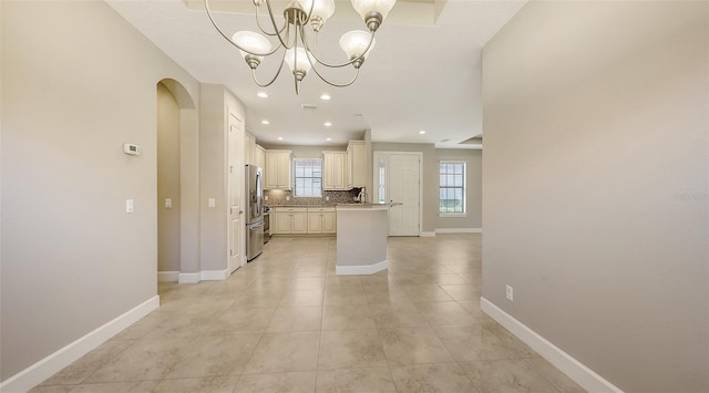 12619 Sorrento Way, Bradenton, FL 34211 - kitchen with freestanding refrigerator, tasteful backsplash, baseboards, light tile patterned floors, and a center island