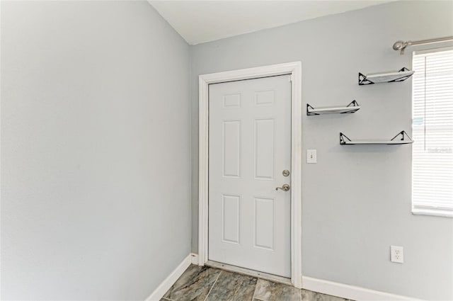 doorway featuring baseboards and wood finished floors