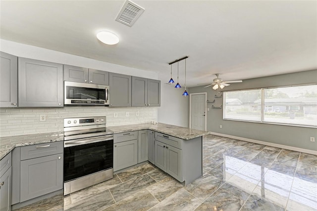 kitchen featuring stainless steel appliances, gray cabinetry, a peninsula, and tasteful backsplash