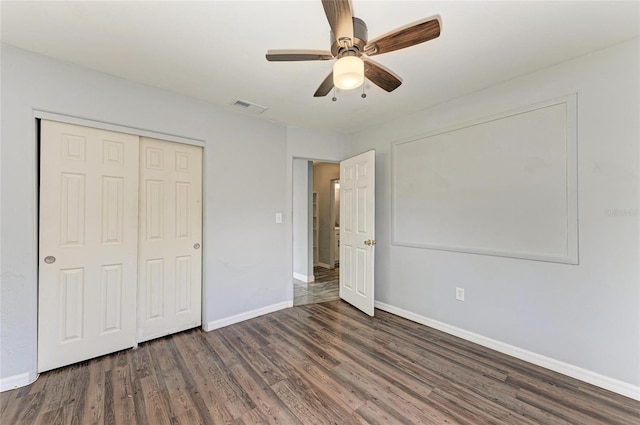 unfurnished bedroom featuring wood finished floors, baseboards, and a closet