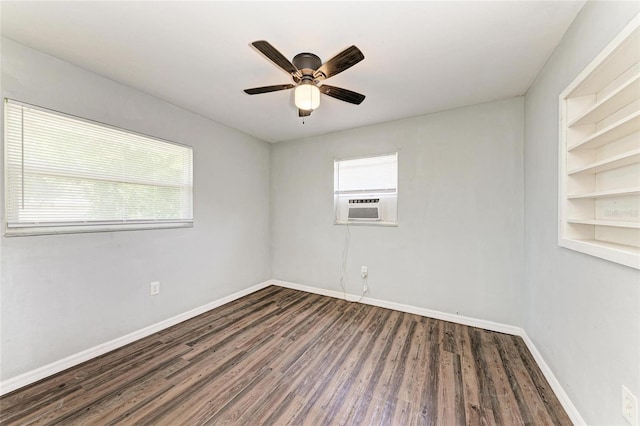 unfurnished room featuring healthy amount of natural light, wood finished floors, and baseboards