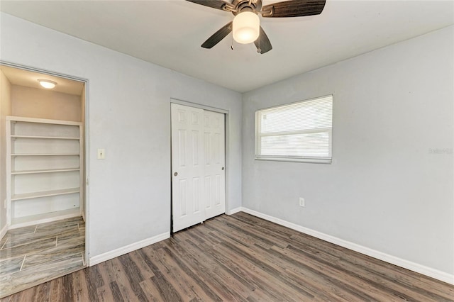 unfurnished bedroom featuring wood finished floors, baseboards, a closet, and a ceiling fan