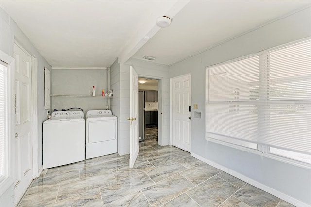 laundry room with washer and clothes dryer and marble finish flooring
