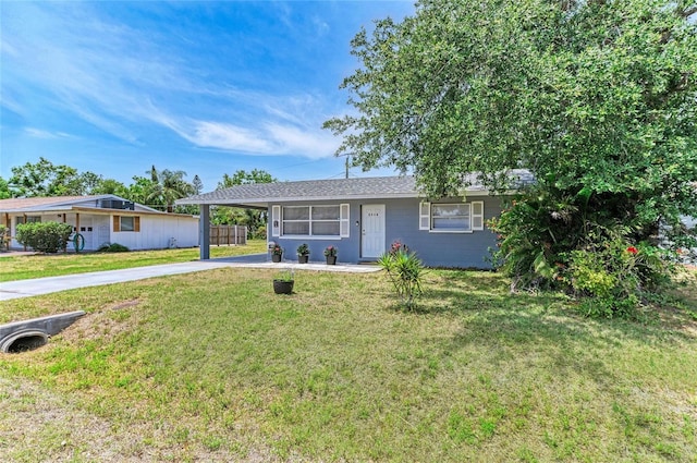 ranch-style house featuring concrete driveway, a carport, and a front yard