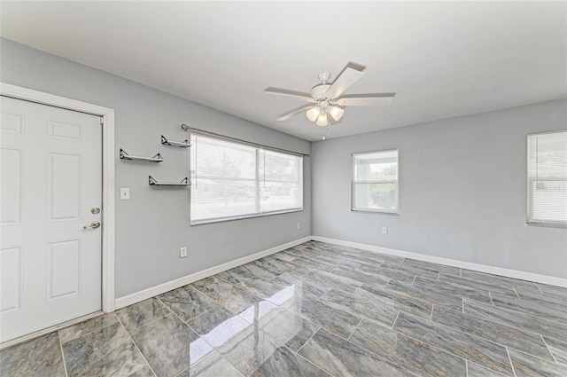 entrance foyer with ceiling fan and baseboards