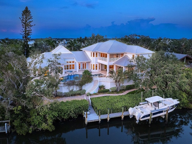 5132 Jungle Plum Rd, Sarasota, FL 34242 - rear view of property featuring a balcony, an outdoor pool, a water view, metal roof, and boat lift