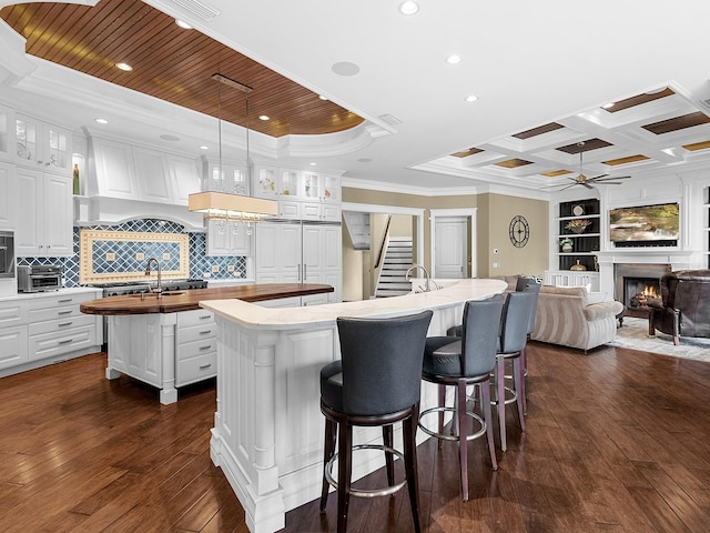 5132 Jungle Plum Rd, Sarasota, FL 34242 - kitchen with a center island with sink, wooden counters, crown molding, ceiling fan, and dark wood-style floors