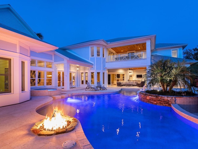5132 Jungle Plum Rd, Sarasota, FL 34242 - pool at twilight with a pool with connected hot tub, an outdoor living space with a fire pit, french doors, and a patio area
