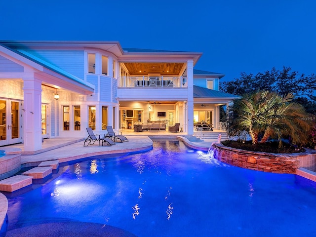 5132 Jungle Plum Rd, Sarasota, FL 34242 - back of house at twilight with a balcony, a patio, french doors, an outdoor hangout area, and a pool with connected hot tub