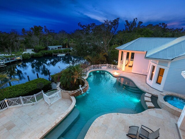 5132 Jungle Plum Rd, Sarasota, FL 34242 - pool at dusk featuring a patio area, a pool with connected hot tub, and a water view