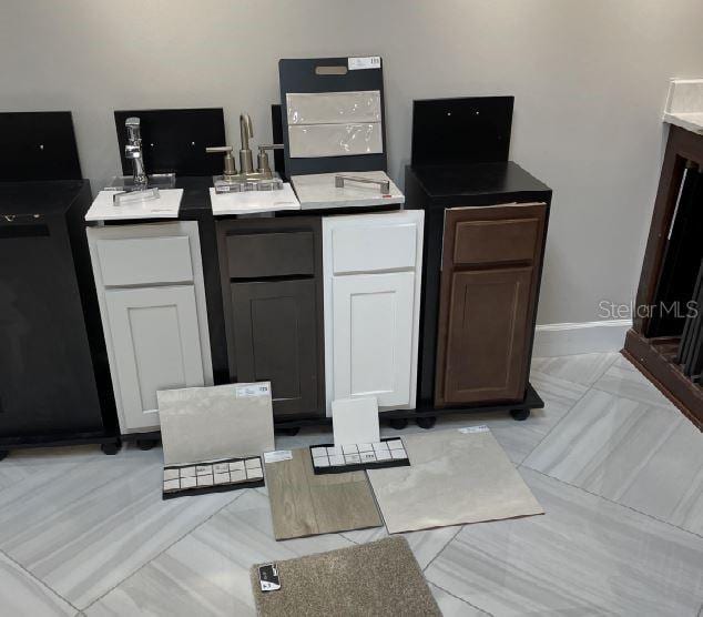 kitchen featuring baseboards and white cabinets