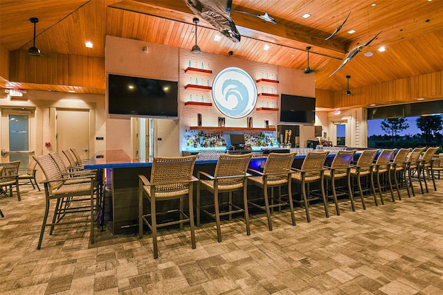 bar featuring carpet, a high ceiling, beam ceiling, a community bar, and wooden ceiling