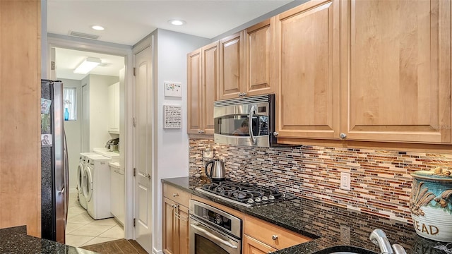 235 Cocoanut Ave Unit 108B, Sarasota, FL 34236 - kitchen featuring appliances with stainless steel finishes, separate washer and dryer, light tile patterned floors, light brown cabinets, and tasteful backsplash