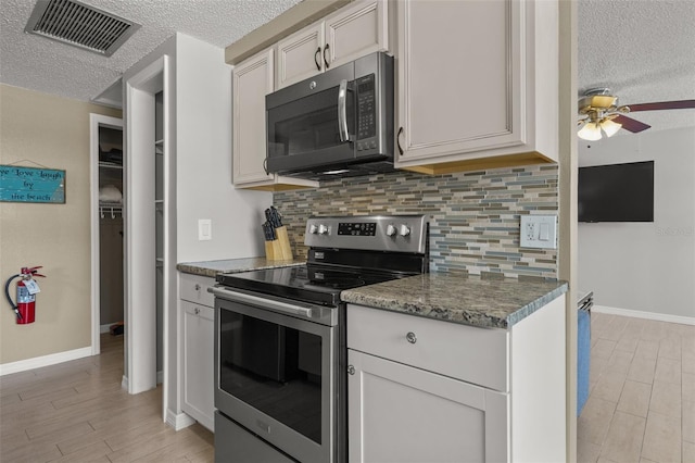 kitchen with stainless steel range with electric stovetop, a textured ceiling, ceiling fan, backsplash, and light wood finished floors