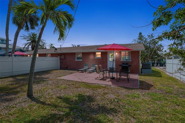 rear view of house featuring stucco siding, a patio, and central AC unit