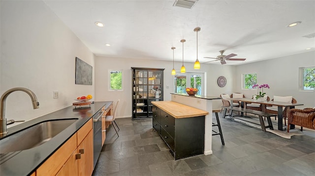kitchen featuring a sink, a breakfast bar, butcher block counters, recessed lighting, and dishwasher