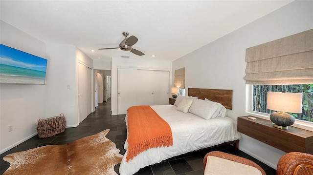 bedroom with a ceiling fan, two closets, recessed lighting, baseboards, and tile patterned floors