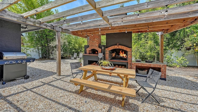 view of patio with an outdoor brick fireplace, area for grilling, and a pergola