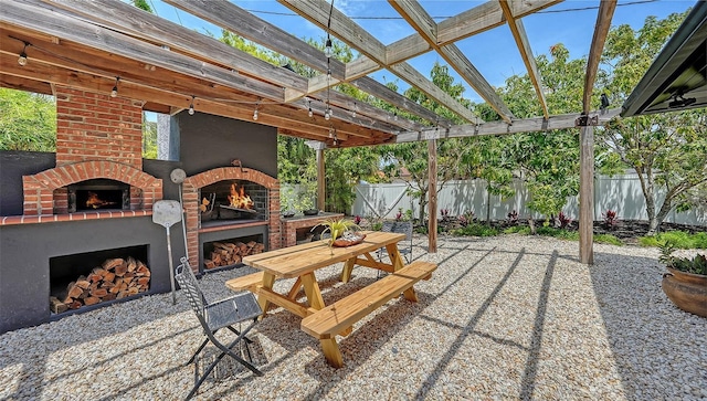 view of patio / terrace with an outdoor brick fireplace and fence