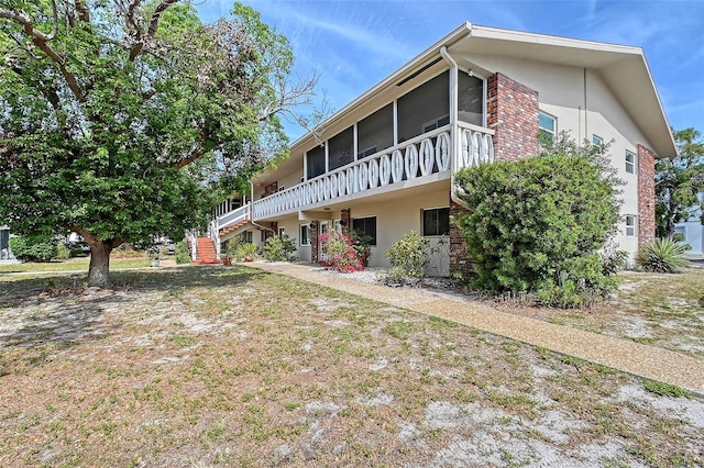 3705 S School Ave Unit 3, Sarasota, FL 34239 - view of side of property featuring a sunroom, stucco siding, and stairs