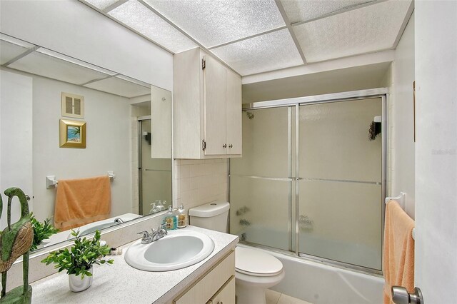 3705 S School Ave Unit 3, Sarasota, FL 34239 - bathroom featuring toilet, a paneled ceiling, shower / bath combination with glass door, and vanity