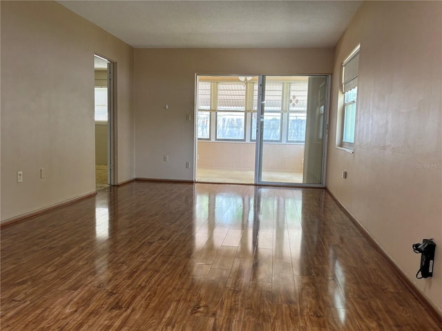 empty room featuring baseboards and wood finished floors