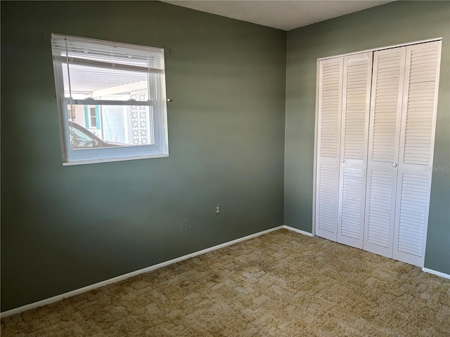 unfurnished bedroom featuring carpet flooring, a closet, and baseboards