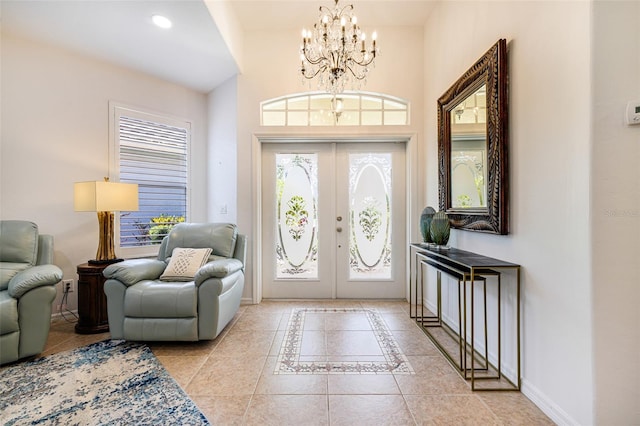 20040 Rookery Dr, Estero, FL 33928 - tiled foyer featuring french doors, baseboards, a chandelier, a high ceiling, and inlaid floor details