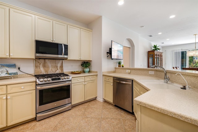 20040 Rookery Dr, Estero, FL 33928 - kitchen with cream cabinets, appliances with stainless steel finishes, a sink, recessed lighting, and light tile patterned flooring